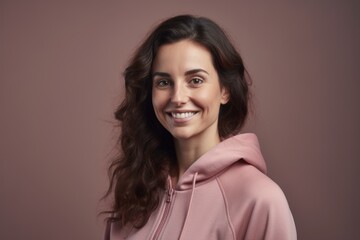 Wall Mural - Portrait of a beautiful young brunette woman in a pink hoodie.