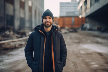 Canvas Print - young handsome hipster man in black jacket and hat posing in an urban context