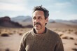 © Robert MEYNER - Medium shot portrait photography of a satisfied man in his 40s wearing a cozy sweater against a desert background. Generative AI