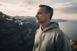 Lifestyle portrait photography of a pleased man in his 40s wearing a comfortable tracksuit against a panoramic landscape background. Generative AI