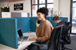 © Meeko Media - Multi-ethnic woman answers phone, working next to colleague in office