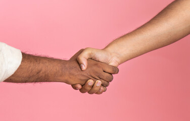 Shaking hands of two male people isolated on pink colour background