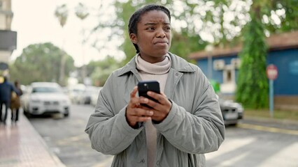 Poster - African american woman using smartphone with serious expression at street