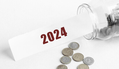 Poster - paper with the text 2024 in a glass jar on a background of coins