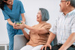 A female nurse serves a bowl of salad to a contented senior couple. Health care and medical assistance for the elderly, nursing home for pensioners.