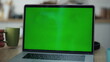© stockbusters - Closeup greenscreen laptop computer on office table. Unknown man working chroma