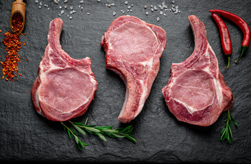 Wall Mural - Fresh, raw pork steak with spices on a dark background