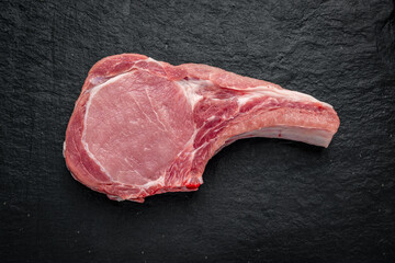 Wall Mural - Fresh, raw pork steak on a dark background