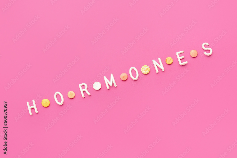Word HORMONES on pink background
