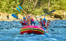 Team Of Cheerful Travelers Are Rafting On A Boat On A Stormy River