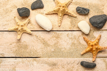 Wall Mural - Sand with starfishes and shells on beige wooden background