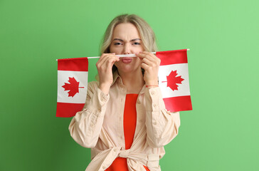 Sticker - Young woman with flags of Canada on green background