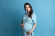 Beautiful pregnant woman standing on blue background. Ai generative.