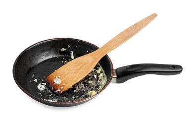 Dirty frying pan and wooden spatula on white background