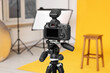 © New Africa - Camera on tripod, bar stool and professional lighting equipment in modern photo studio