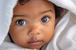 Close up shot of cute baby, of African ethnicity, with head covered by a white blanket.  Generative AI.