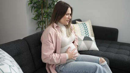 Canvas Print - Young pregnant woman touching belly suffering for backache at home