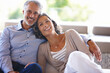 © Laflor/peopleimages.com - Portrait, smile and senior couple on a couch, love and relationship with joy, home and happiness. Face, mature man and old woman on a sofa, retirement and cheerful with marriage, bonding and loving
