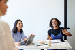 © Cavan Images - Happy female entrepreneurs sitting at desk during meeting at cafe