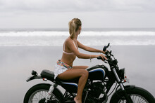 Woman Travels On A Motorcycle In The Ocean Beach.