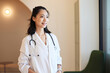 © Cavan Images - Smiling female doctor with stethoscope standing in clinic
