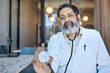 © Cavan Images - Portrait of male doctor holding stethoscope in clinic