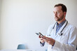 © Cavan Images - Male healthcare worker using smart phone while standing in clinic