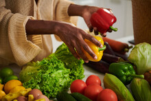 Woman Taking Red And Yellow Bell Peppers For Recipe