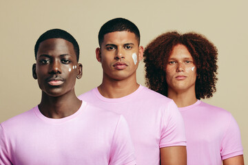Wall Mural - Group of diverse youthful men using a beauty product on their unique skin tones