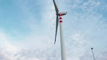 Wind Turbine Is Moving Slow Under Blue Sky 
