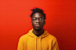 © ruang - Young african american man in a yellow hoodie on a red background. Generative AI