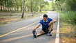© bongkarn - Fit and sporty Asian man stretching his legs on the street, warming up before running.