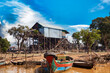Boats and houses on stilts on rural river, Kompong Phluk floating fishing village in drought season. Tonle Sap lake, life and work cambodian people, residents poverty country Cambodia. Copy text space