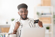 © Egoitz - African american man celebrating online purchase