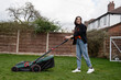 © Cultura Creative - Woman wearing hijab mowing grass in backyard