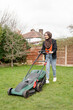 © Cultura Creative - Woman wearing hijab mowing grass in backyard