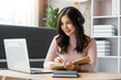 © Natee Meepian - Young business freelance Asian woman working on laptop checking social media while sit on the sofa when relax in living room at home. Lifestyle at house concept