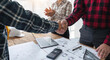 © Natee Meepian - engineer construction shaking hands while working for teamwork and cooperation concept after finish an agreement in the office construction site, success collaboration concept