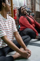 Wall Mural - Mother and daughter stretching on mat in gym