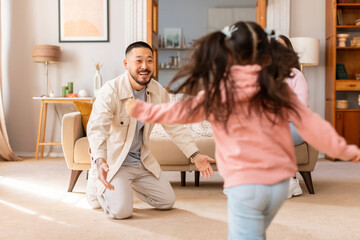 Wall Mural - Asian Little Daughter Running To Embrace Daddy At Home