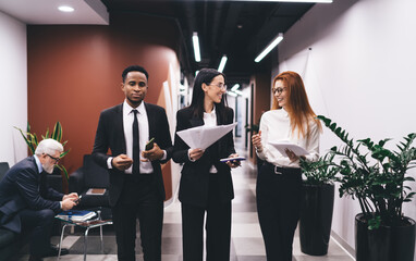 Wall Mural - Diverse businesspeople talking to each other while walking in office