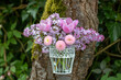 Blumenstrauß mit pink Bellis perennis, Tulpen und Flieder in vintage Vase