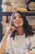© Tatyana - Portrait of a happy young dark-haired woman sitting in a cafe.
