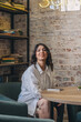 © Tatyana - Portrait of a happy young attractive dark-haired woman in a cafe.