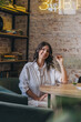 © Tatyana - Portrait of a happy young attractive dark-haired woman in a cafe.
