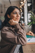 © Tatyana - Attractive smiling young woman makes notes in her notebook in a cafe.Remote work,business,freelance concept.