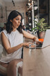 © Tatyana - Attractive positive young woman using a laptop in a cafe.Remote work,blogging,business, freelance,e-learning.