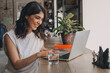 © Tatyana - Attractive positive young woman using a laptop in a cafe.Remote work,blogging,business, freelance,e-learning.
