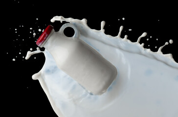 Wall Mural - full milk bottle with milk splashes isolated on black background