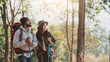 © NewSaetiew - Travelers hiking with backpack traveling in forest wild and look around and explore while walking in nature wood. happy holiday vacation trip.